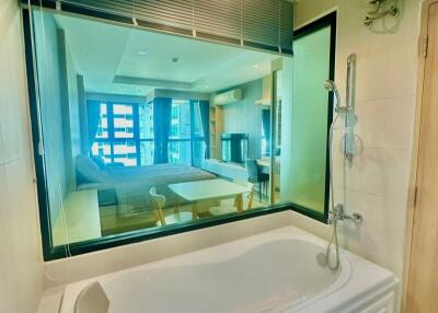 Modern bathroom with glass see-through wall overlooking the bedroom