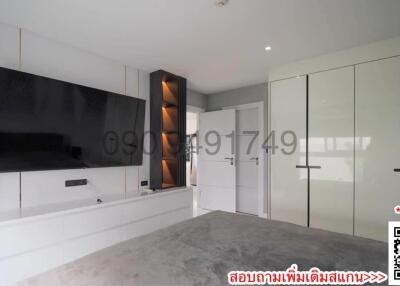 Spacious and modern bedroom with built-in wardrobes and television