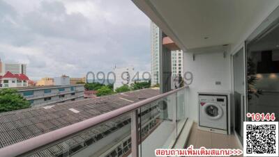 Spacious balcony overlooking city with washing machine