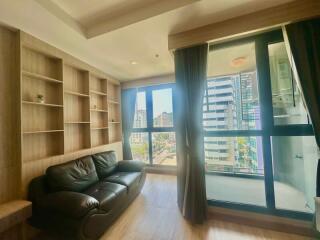 Cozy living room with a leather sofa and built-in bookshelves