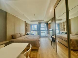 Modern bedroom with large bed, wooden panels, and ample natural lighting