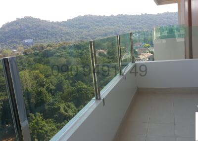 Spacious balcony with a panoramic mountain view and glass railing
