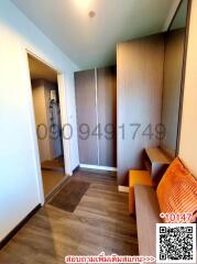 Compact hallway with wooden flooring, built-in cabinets, and a small seating area