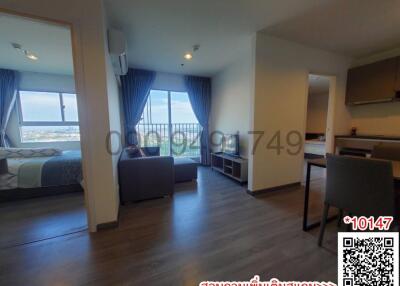 Spacious studio apartment with open layout featuring kitchen area, living space, and bedroom