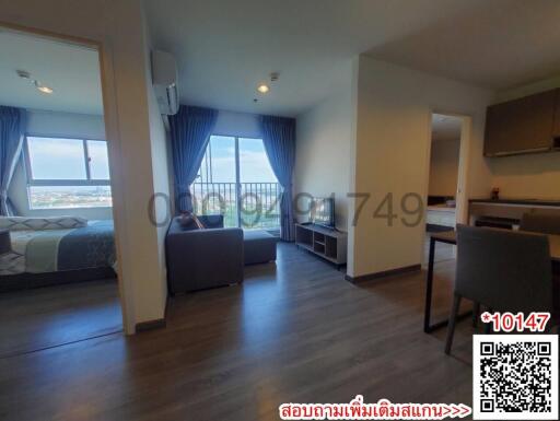Spacious studio apartment with open layout featuring kitchen area, living space, and bedroom