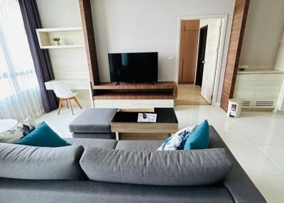 Modern living room with large sofa and wooden TV frame