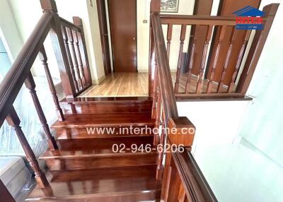 Elegant wooden staircase with polished handrails leading to upper floor