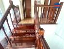 Elegant wooden staircase with polished handrails leading to upper floor