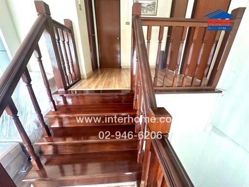 Elegant wooden staircase with polished handrails leading to upper floor