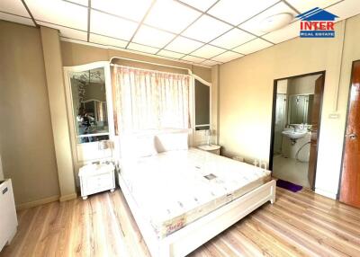 Spacious bedroom with wooden flooring and attached bathroom
