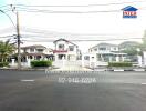 Elegant two-story residential house with landscaped front yard and gated entrance