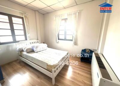 Bright and well-furnished bedroom with wooden flooring