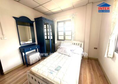 Bright bedroom with wooden floors and elegant blue furniture