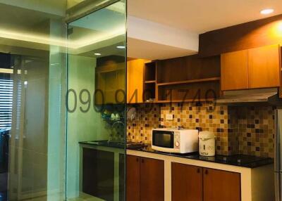 Modern kitchen with glass partition and wooden cabinets
