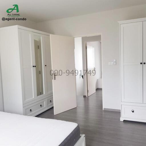 Spacious and well-lit bedroom with large wardrobe and wooden flooring