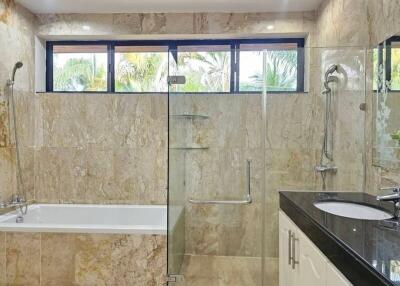 Spacious modern bathroom with marble finishes and garden view