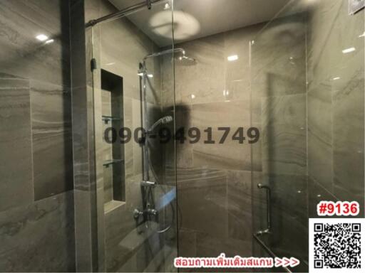 Modern bathroom with glass shower enclosure and marble walls