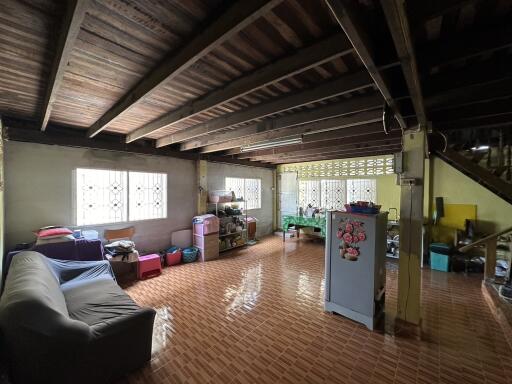 Spacious living room with exposed beams and tiled flooring