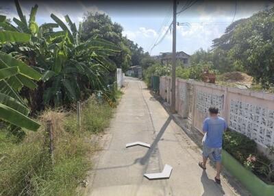 Residential street view in Bangkok with pedestrian and greenery