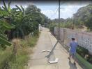 Residential street view in Bangkok with pedestrian and greenery