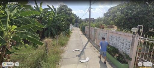 Residential street view in Bangkok with pedestrian and greenery