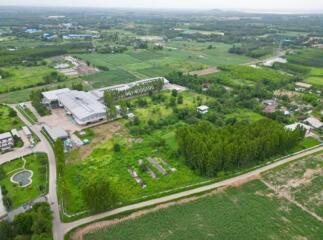 Aerial view of a large property with surrounding greenery and industrial buildings