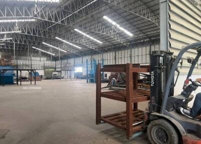 Spacious industrial warehouse interior with high ceilings and forklift
