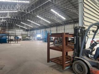 Spacious industrial warehouse interior with high ceilings and forklift