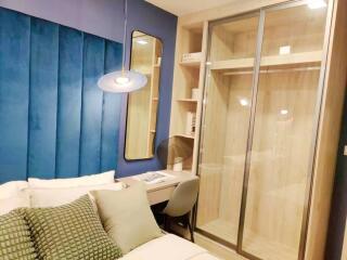 Modern bedroom with elegant interior design, blue walls, and ample lighting