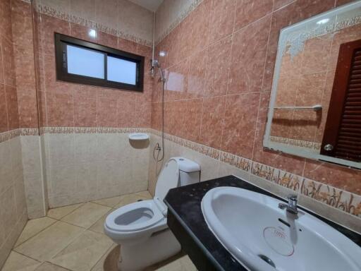 Spacious bathroom with tiled walls and modern fixtures