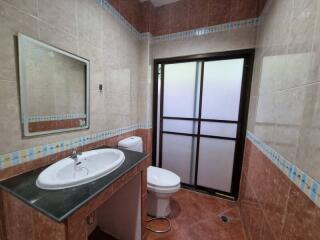 Spacious bathroom with large mirror and glass door