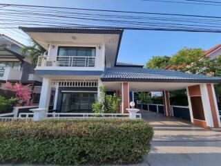 Modern two-story house with a covered carport and balcony