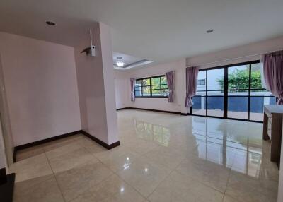 Spacious and bright living room with large windows and glossy tiled flooring