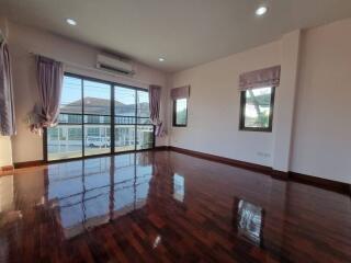 Spacious and bright living room with polished wooden floors and large windows