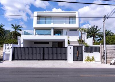 Modern two-story house with a sleek design and a large entrance gate