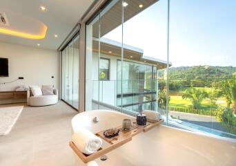 Luxurious bathroom with large bathtub, floor-to-ceiling windows, and scenic view