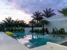 Luxurious pool area with tropical landscaping and sunset view