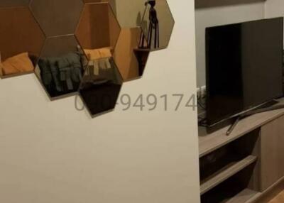 Modern living room with geometric wall shelf and flat-screen TV