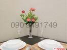 Elegantly set dining table for two with floral centerpiece