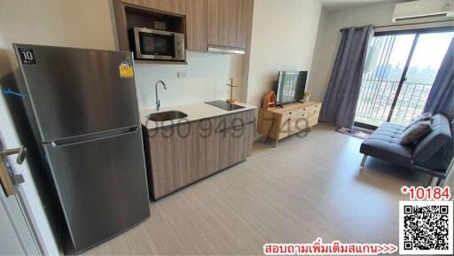 Spacious combined kitchen and living room area with modern appliances and ample natural light