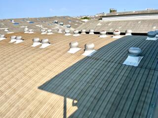 Industrial building roof with ventilation systems and skylights