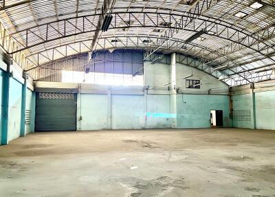 Spacious industrial warehouse with metallic roofing and wide garage door