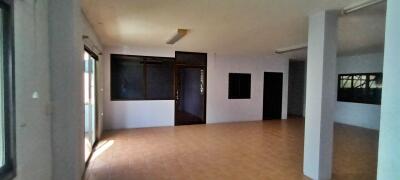 Spacious unfurnished living room with large windows and tiled flooring