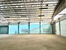 Spacious empty warehouse interior with multiple loading docks and natural light