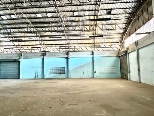 Spacious empty warehouse interior with multiple loading docks and natural light