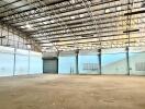 Spacious industrial warehouse interior with high ceiling and multiple ventilation options