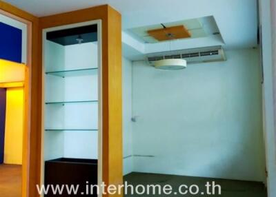 Modern air-conditioned living space with built-in shelving and sleek storage solutions