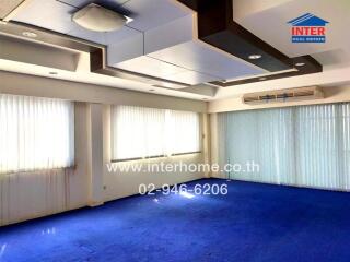 Spacious living room with blue carpet and natural light