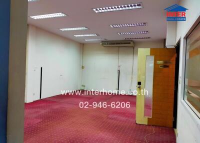 Spacious commercial space with pink carpet and bright lighting