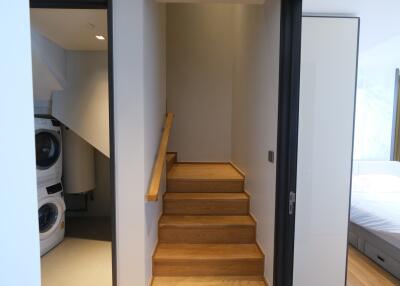 Bedroom interior with staircase and laundry appliances